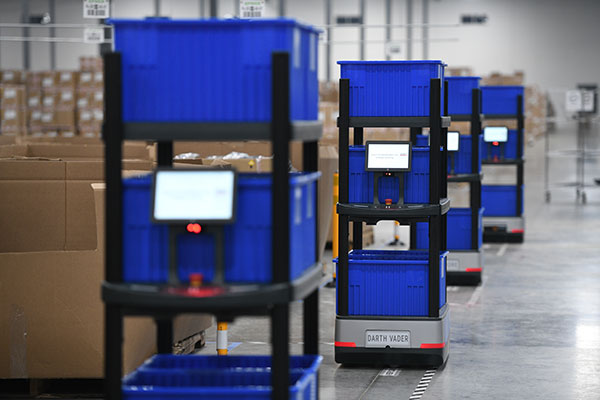 System-Directed Picking Robots Versus Swarming Robots
