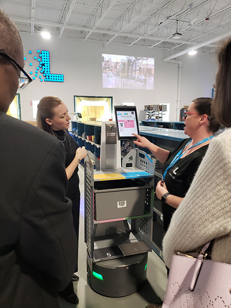 Each picker wears a patented low-energy Bluetooth tag that tells the system where they are and what languages they speak, changing the interface language as the robot approaches.