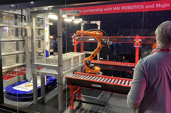 ​Robotics 24/7 was inundated with press releases about corporate partnerships leading into MODEX 2022. Many of these reflect efforts to broaden product portfolios, gain access to adjacent markets, and deepen engineering teams.

Examples included Murata Machinery and AGVE Group collaborating on automated guided vehicles (AGVs), Vecna Robotics and Big Joe’s autonomous pallet jack, and GXO Logistics working with Locus Robotics, among other suppliers.

In addition, Honeywell demonstrated robot arms with OTTO Motors’ AMRs, Oceaneering chose BlueBotics’ navigation tech for its robots, while Berkshire Grey and Swisslog showed how AI can aid order fulfillment.

Still more partnerships included Addverb’s AMRs with Numina Group’s distribution software, as well as Caja Robotics and Ranpak’s packaging system. Plus One Robotics and Tompkins Robotics jointly offered systems for sortation.

Material Handling Systems (MHS) had one of the coolest displays, with black walls and red lights, plus a mixed-case palletizing demonstration with Mujin and HAI Robotics, as seen in this photo.