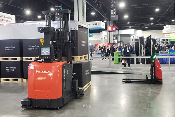 VisionNav unveiled its new VNST20 PRO automated guided vehicle (AGV) pallet jack (right) at the show. Shown here is a VNST20 performing trailer loading and unloading alongside other VisionNav products.